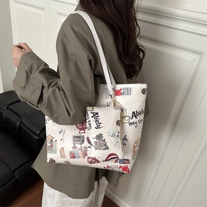 White tote bag set with colorful city illustration and matching pouch on model shoulder