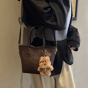 Deep coffee vintage textured tote bag with cute plush puppy charm and long shoulder strap
