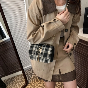 Sac bandoulière chic en tweed noir et blanc avec boucle en S dorée et pendentif à gland