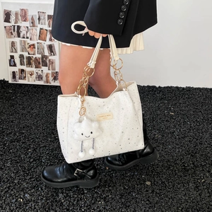 Chic white tote bag with silver star patterns and cloud charm on a shoulder strap