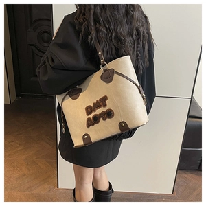 Dettaglio della borsa vintage con scritte in peluche DAT AOTO e finiture in pelle marrone