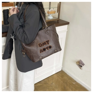 Vista dettagliata della borsa tote marrone vintage con ricamo in peluche e trama in pelle