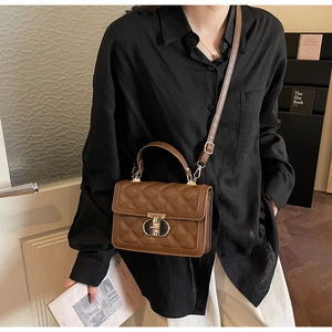 Detail of brown quilted crossbody bag with vintage gold twist lock and elegant top handle