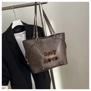 Dettaglio della borsa tote marrone vintage con scritte in peluche DMT AOTO su supporto