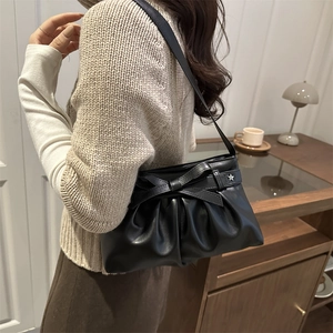 Sac à épaule en cuir noir élégant avec détail nœud et breloque étoile en décor lifestyle