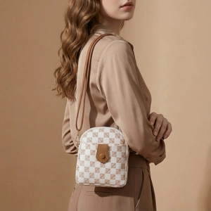 Detail view of mini checkerboard crossbody bag with brown leather strap and buckle