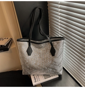 Silver metallic woven tote bag close-up with black leather handles and modern texture