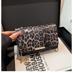 Détail d'un sac à bandoulière léopard avec chaîne dorée et boucle métallique élégante