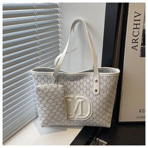 Dettaglio del set borsa shopper bianca con stampa motivo M e logo tondo a rilievo