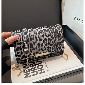 Détail du sac à rabat imprimé léopard avec chaîne dorée sur un magazine urbain