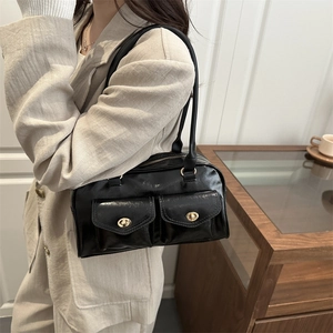 Classic black glossy faux leather shoulder bag with dual gold twist-lock pockets