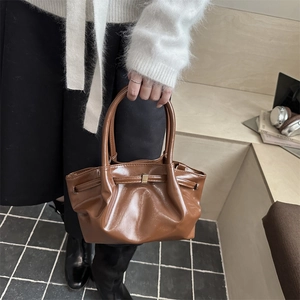 Brown ruched cloud bucket bag in glossy PU leather with gold buckle detail and top handle