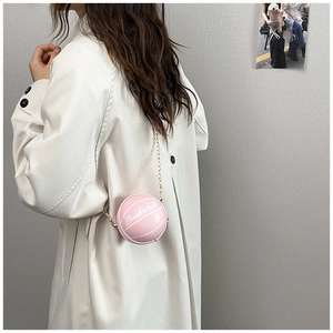 Vista de detalle del mini bolso rosa con forma de baloncesto y correa de cadena dorada