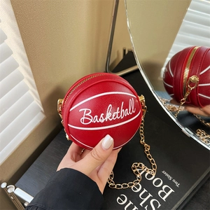 Detail of red basketball-shaped bag with white stitching and gold chain strap