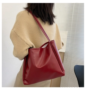 Detail of burgundy PU leather tote bag with slim shoulder straps for casual commuting