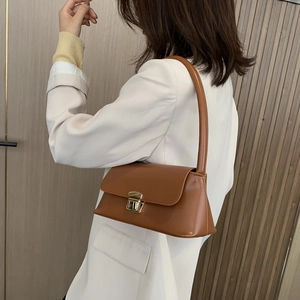 Classic brown leather underarm handbag with gold metallic buckle for stylish women