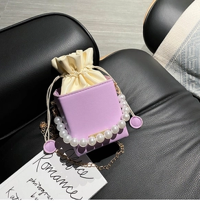 Detail of purple square box bag with large pearl handle and golden chain strap