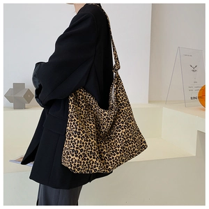 Grande borsa tote leopardata indossata a spalla con un blazer nero oversize