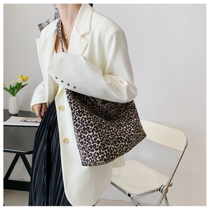 Borsa tote leopardata indossata con blazer bianco e gonna nera per un look elegante