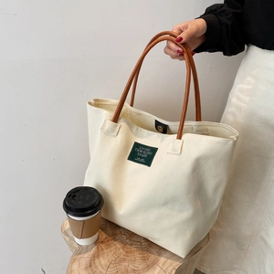 Borsa tote in tela bianco crema con manici in pelle marrone e chiusura magnetica