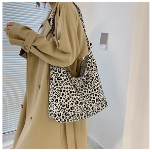 Grande borsa tote con stampa leopardata indossata con un classico trench color kaki scuro