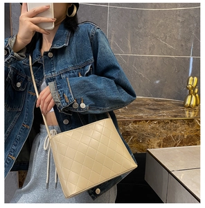 Dettaglio della borsa a tracolla beige trapuntata con cuciture a rombi e cinturino