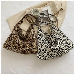 Dettaglio delle borse hobo leopardate con tracolle annodate su tessuto estetico