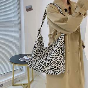 Grande borsa tote in tela con stampa leopardata e tracolla annodata indossata da modella