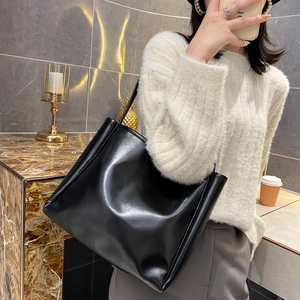 Simple black faux leather tote bag with large capacity for women on marble background