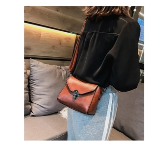 Detail of retro caramel leather handbag with vintage metal flip lock and swivel clasp