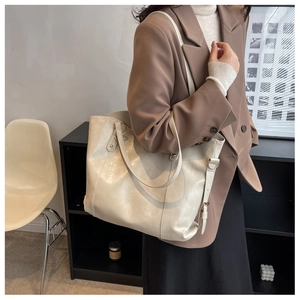 Détail du sac cabas blanc cassé avec texture litchi et surpiqûres en U