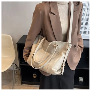 Vue détaillée du sac cabas crème en similicuir souple avec boucle latérale en métal poli