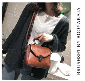 Detail view of brown vintage mini square bag with leather texture and twist lock