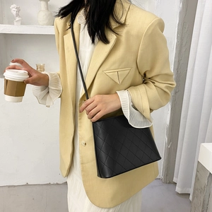 Elegante borsa a tracolla trapuntata nera con motivo a rombi e cinturino sottile su modella