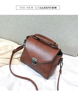 Close-up of vintage brown leather handbag with metallic buckle and detachable strap