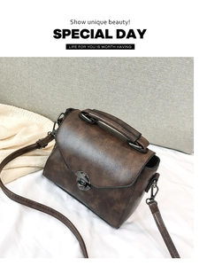 Close-up of vintage dark brown handbag featuring lychee texture and metallic lock detail