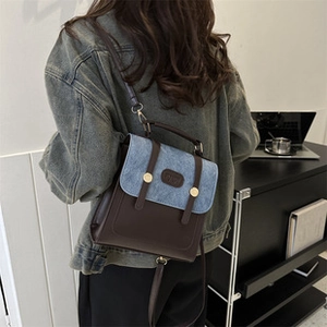 Close-up of contrast denim and brown leather stitching with vintage gold buckles
