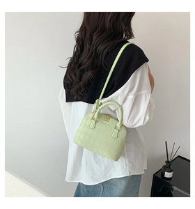 Détail d'un sac à main matelassé vert clair avec des finitions dorées élégantes