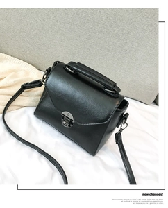 Close-up of black retro handbag with silver metal swivel lock and adjustable strap