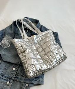 Détail du sac cabas matelassé argenté avec finition métallique brillante et doubles poignées