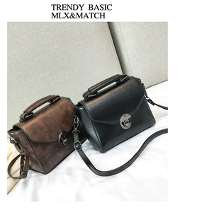 Close-up of black and brown retro PU leather handbags with metal locks and top handles