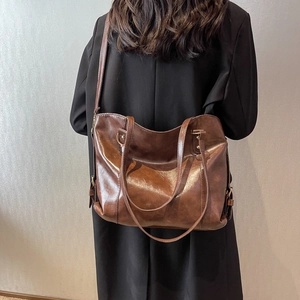 Sac cabas classique en cuir marron avec détails dorés porté par un mannequin