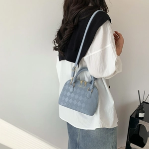Sac à main bleu clair en forme de coquille avec gaufrage et détails dorés