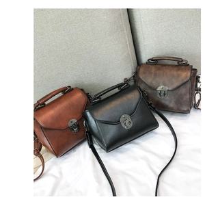 Three vintage style mini handbags in tan, black and brown colors with metal locks
