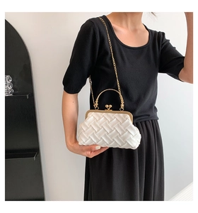 Detail of white pleated clutch bag with gold round handle and spherical metal clasp