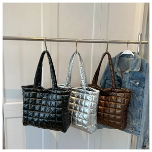 Détails de sacs fourre-tout matelassés en finitions noir, argent et marron brillant