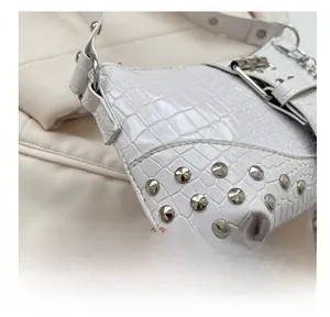 Detailansicht der weißen Handtasche mit Krokodilprägung, silbernen Nieten und Kette