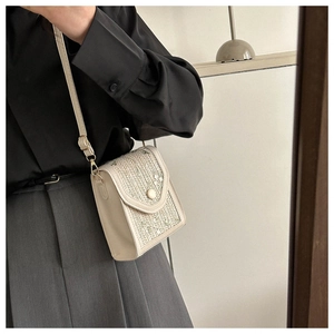 Détail du sac crème bandoulière avec broderie de feuilles et bandoulière réglable