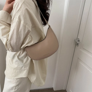 Minimalist khaki saddle shoulder bag for women with elegant curved leather design