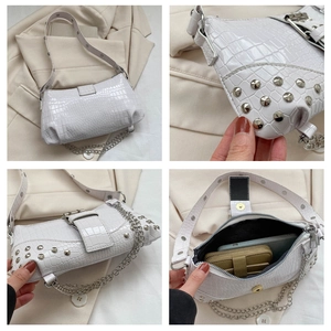 Detail der weißen Handtasche mit Krokostruktur, Silbernieten und Metallkettenriemen